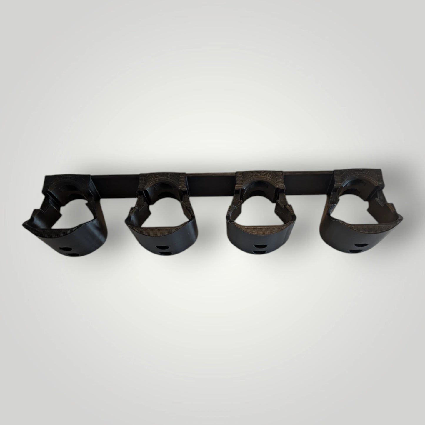 Schwarzer 3D-gedruckter Wandhalter für Wasserflaschen.