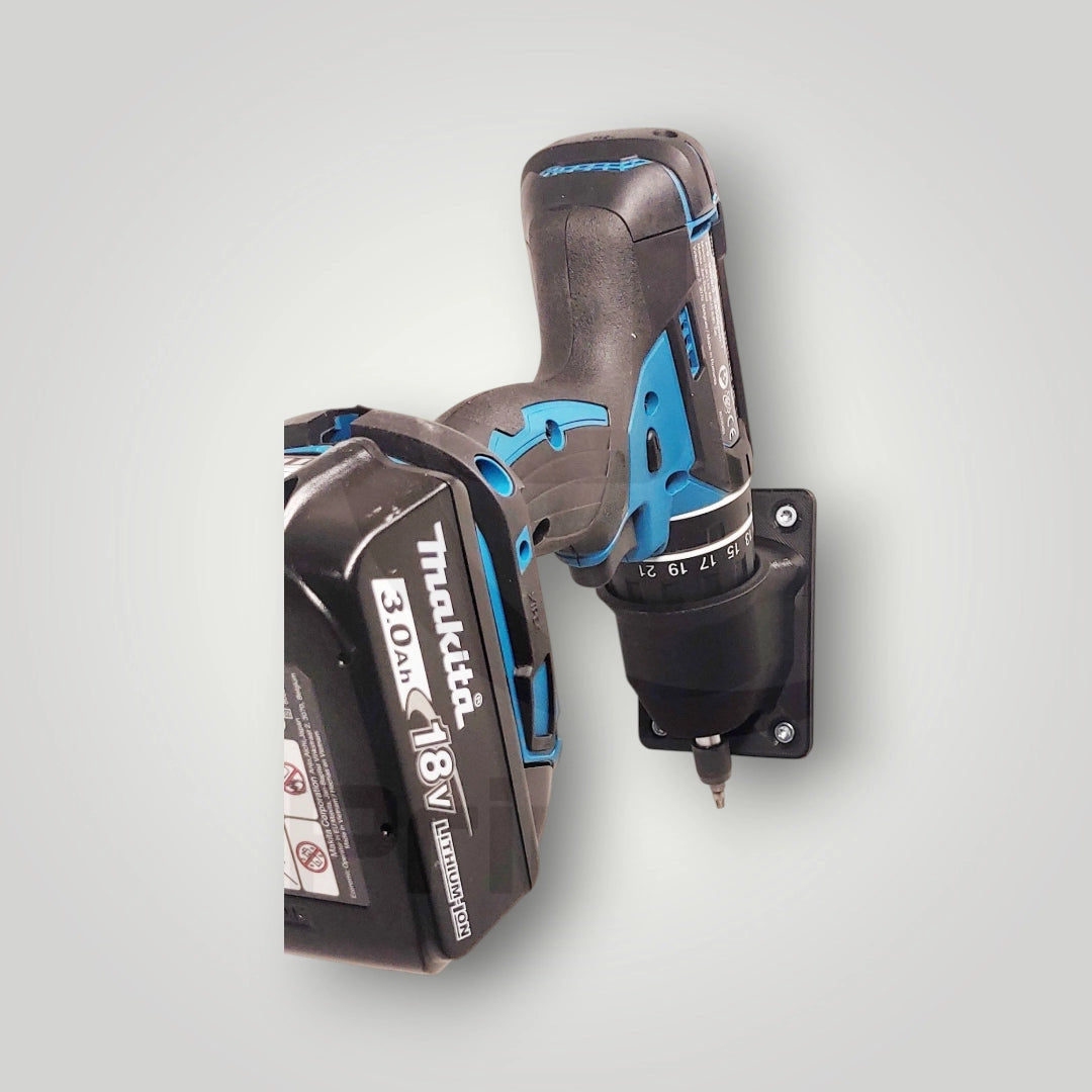 A Makita Akkuschrauber 18V is vertically mounted on the wall with a black Wandhalter für Makita Akkuschrauber 18V—ideal for Werkstatt Aufbewahrung. The tool’s sleek black body and blue accents add a stylish touch.